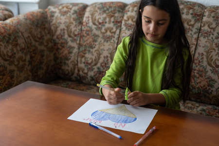 Ukrainian flag and a heart in yellow and blue color. Child draws a heart on the blackboardの写真素材
