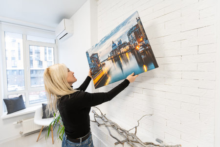 Photo canvas print. A woman holding a photography with gallery wrap. Photo printed on glossy...