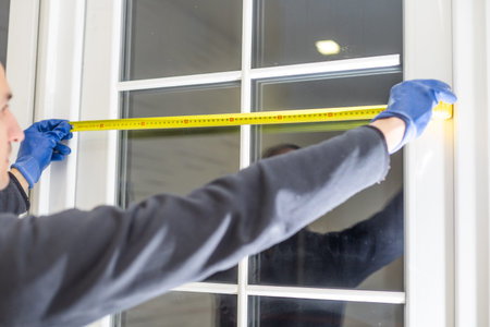 Construction worker installing window in house