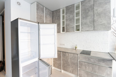 Interior of the small living equipped kitchen in studio apartments in minimalistic style with light colorの写真素材