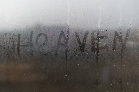 Word Heaven, Handwritten inscription on the glass. Water drops on the window glassの写真素材