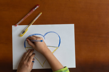 A little girl draws a heart. Top view. Copy space for textの写真素材
