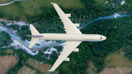 Aerial view of aircraft. Airplane is flying over mountains with forest. Business travel. Commercial...