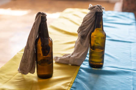 Molotov cocktail, martial law in Ukraine, a combustible mixture in bottles with a rag lies on the flag of Ukraine, war Ukraine 2022の写真素材