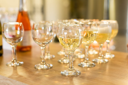 Low angle close up perspective of crystal clear wine glass in warm light background