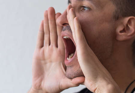 man exclaims with his handsの写真素材