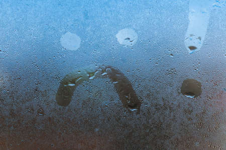 Sad smile inscription on the foggy glass backgroundの写真素材