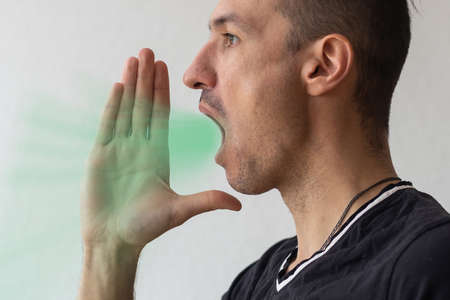Handsome happy man wearing T-shirt, guy speaking loudly, isolated on white backgroundの写真素材