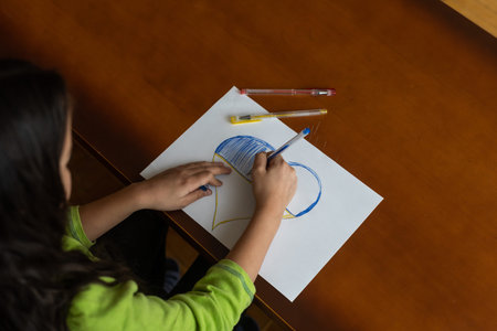 Childrens hand with pencil draws the heartlの写真素材