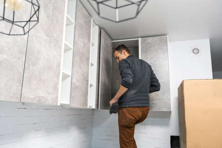 furniture assembly - worker installing cabinet shelfの写真素材