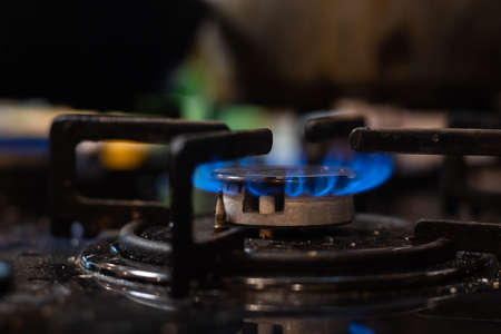 Closeup shot of blue fire from domestic kitchen stove top. Gas cooker with burning flames of propane gas. Industrial resources and economy conceptの写真素材