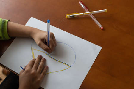Childrens hand with pencil draws the heartlの写真素材