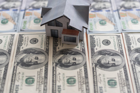 one hundred dollar bills and a paper house, real estate sale houses concept business in a pandemic
