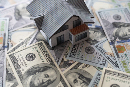one hundred dollar bills and a paper house, real estate sale houses concept business in a pandemic