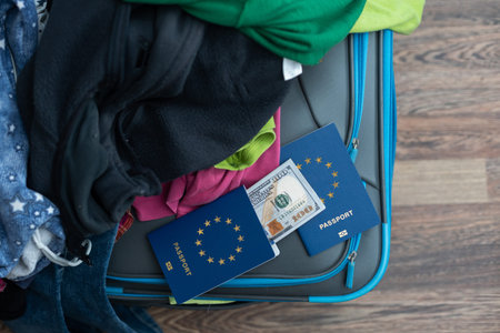 Holiday suitcase. scattered clothes, passport, money