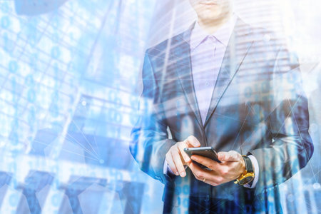The double exposure image of the business man using a smartphone during sunrise overlay with...