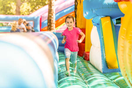 Joyful little girl playing on a trampolineの写真素材