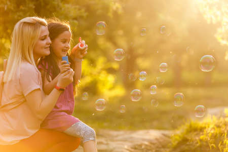 Mother and daughter family time, blowing bubblesの写真素材