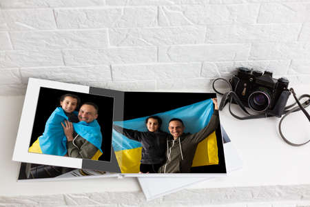 on white table open photobook from photo shoot of family with ukraine flagの写真素材