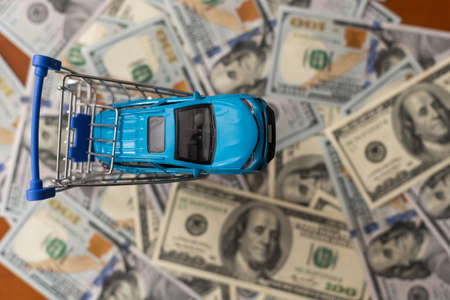 One hundred dollar banknotes with small, toy car.の写真素材