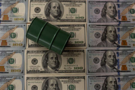 a barrel and dollar bills on a white background.の写真素材
