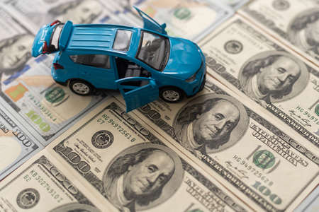 One hundred dollar banknotes with small, toy car.の写真素材
