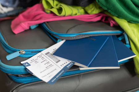 Holiday suitcase. scattered clothes, passport, moneyの写真素材