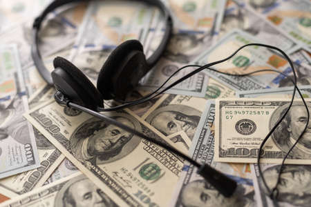 one hundred dollar bills and headphones. Close-up.の写真素材