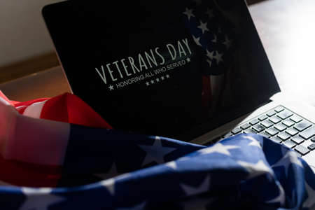 veterans day written in laptop with flag of the United States, on a rustic wooden backgroundの写真素材