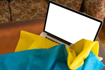 the laptop blank screen on the background of the flag of Ukraine. copy spaceの写真素材