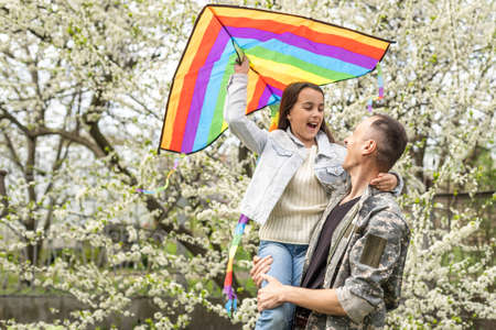 Soldier reunited with his daughter on a sunny day.の写真素材
