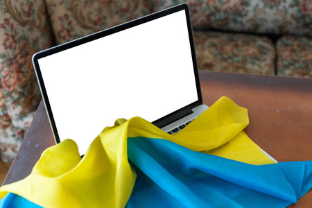 the laptop blank screen on the background of the flag of Ukraine. copy space