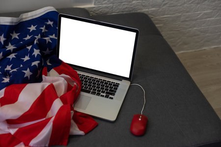 USA Memorial day, Presidents day, Veterans day, Labor day, or 4th of July celebration. Blank screen on modern laptop for mockup design on USA national flagの写真素材