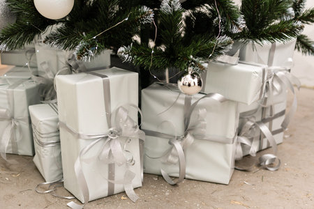 Christmas tree with wooden rustic decorations and presents under it in loft interior.の写真素材