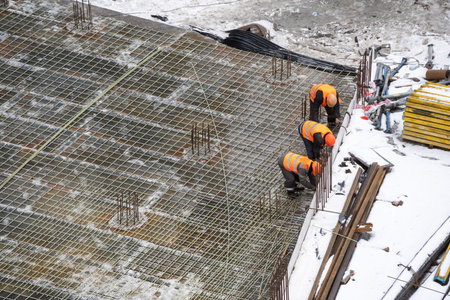 cranes and workers being poured concrete into foundation. Cement pouring into formwork of building...