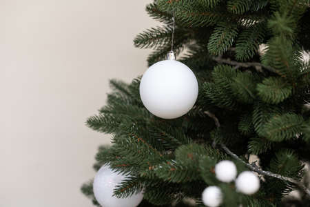 Classic Christmas New Year decorated New year tree with white ornament decorations toy and ball. Modern classical style interior design apartment. Christmas eve at homeの写真素材