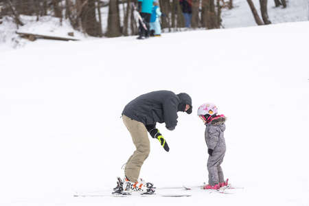 Little boy learning to ski with instructorの写真素材