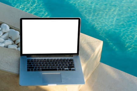 laptop with blank screen near the poolの写真素材