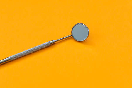 dental mirror on an orange backgroundの写真素材
