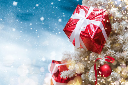 Magically decorated Christmas Tree with balls, ribbons and garlands on a blurred blue shiny, fairy...