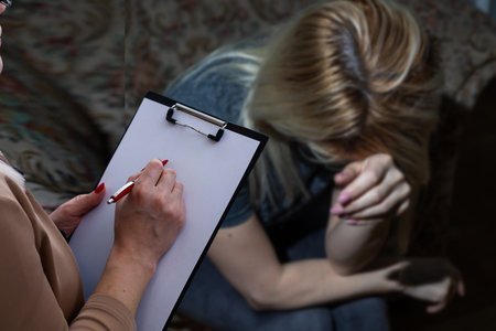 Young woman visiting therapist counselor. Girl feeling depressed, unhappy and hopeless, needs...