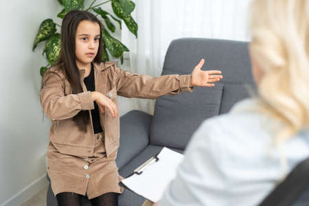 Female psychologist working with little girl at homeの写真素材