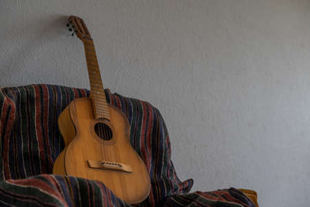 spanish guitar on a old chair with wooden background horizontalの写真素材