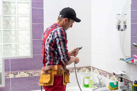 plumber at work in a bathroom, plumbing repair service, assemble and install concept.の写真素材