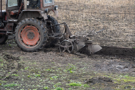 farm tractor with plow plows the field and prepares for sowing.