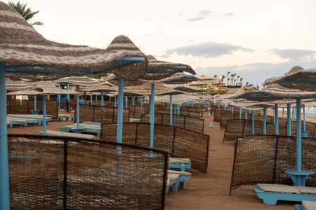 Mediterranean coast with sunbeds and straw sun umbrellas on the sandy beachの写真素材