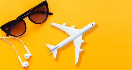 Preparation for Traveling concept, airplane, money, passport on yellow background with copy space.の写真素材