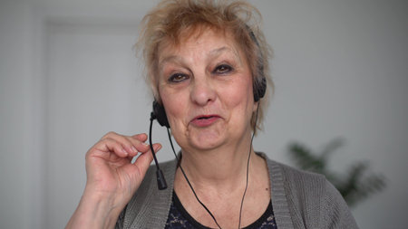Woman in Headphones Talks at Video Chat using Laptop. Self-isolation at COVID-19 Pandemic. woman...