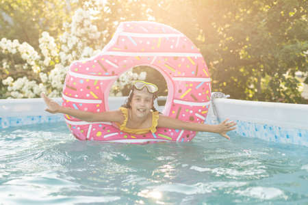 Adorable little girl with inflatable ring at swimming pool.の写真素材