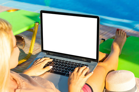 Computer laptop with blank screen near the swimming pool.